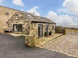 a stone house with a bench in front of it at 1 Bed in Sowerby Bridge 90213 in Sowerby Bridge