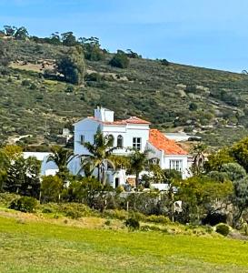 una casa blanca con techo naranja en una colina en La Finca - 3BR Seaside Villa with Private Pool & BBQ, en Tánger
