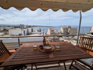 una mesa de madera en un balcón con vistas al océano en Tamar's place, en La Canea