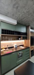 - une cuisine avec des placards verts et un évier dans l'établissement 2403 apartamento Setor Oeste gyn, à Goiânia