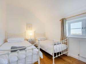 1 dormitorio con 2 camas y ventana en 3 Bed in Newport 90245 en Newport