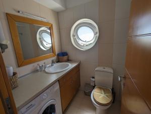 a bathroom with a sink and a toilet and a mirror at Tamar's place in Chania Town