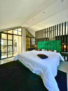 um quarto grande com uma cama grande e uma cabeceira verde em La Finca - 3BR Seaside Villa with Private Pool & BBQ em Tânger