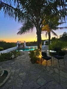 a patio with a table and chairs and a tree at La Finca - 3BR Seaside Villa with Private Pool & BBQ in Tangier