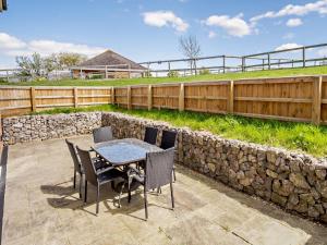 a patio with a table and chairs and a stone wall at 4 Bed in Newport 90249 in Newport