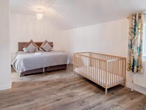 a bedroom with a bed and a crib at 4 Bed in Newport 90249 in Newport