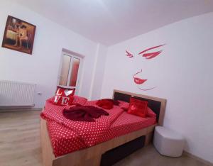 a bedroom with a red bed with red pillows at Cazare Centru Brasov in Braşov