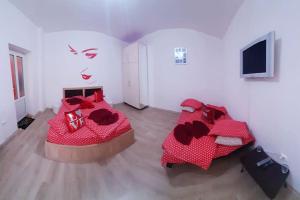 a bedroom with two beds with red comforters at Cazare Centru Brasov in Braşov
