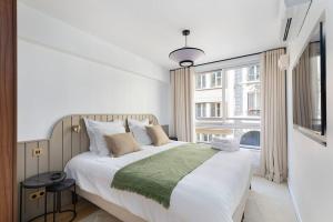 a bedroom with a large bed with a large window at La Perle de Kléber in Paris