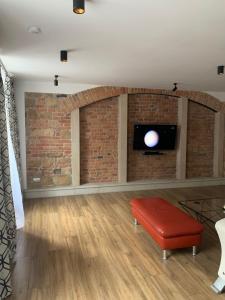 a living room with a brick wall and a tv at Apartament Gold 2 in Złotoryja