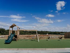 a playground with a slide and a swing at 3 Bed in Newport 90253 in Newport