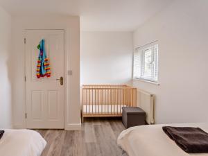 una camera con due letti e una porta con una culla di 2 Bed in Newport 90243 a Newport