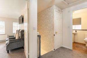 a living room with a chair and a bathroom at Spacious 3-bed Home - Nature Reserve Retreat in Ince-in-Makerfield