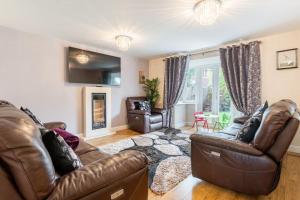 a living room with two leather couches and a table at Spacious 3-bed Home - Nature Reserve Retreat in Ince-in-Makerfield