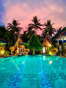 una piscina en un complejo con palmeras en el fondo en Mahaloka Valley Nusa Penida en Nusa Penida