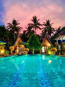 a pool at a resort with palm trees in the background at Mahaloka Valley Nusa Penida in Nusa Penida