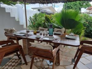 a wooden table and chairs on a patio at 64 ZENJ HOUSE Luxury Airport B&B in Mbweni