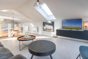 een woonkamer met een bank, een tafel en een tv bij Tinyhouse Fofteinbutze in Nordstrand