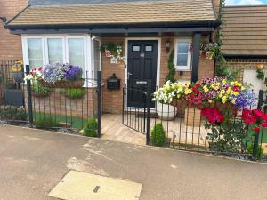 una casa con un cancello con dei fiori sopra di Driver Way a Wellingborough