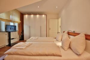 2 Betten in einem großen Zimmer mit einem TV in der Unterkunft Haus Strandallee 150 Ferienappartement Strandallee 150a Appartement 3 in Timmendorfer Strand