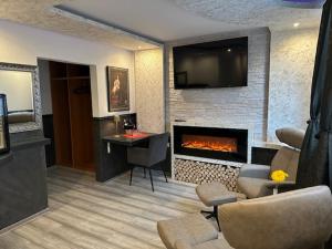 a living room with a fireplace and a tv at Hotel Ristorante Sicilia in Tappenbeck