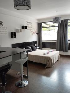Un dormitorio con una cama y un escritorio y un escritorio. en Shaddai Alojamientos, en Salta