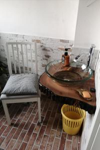 a bathroom with a glass sink and a chair at Ferienwohnung Puttenusenhof in Klausdorf Brandenburg