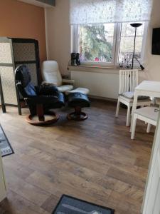 a living room with a chair and a window at Ferienwohnung Puttenusenhof in Klausdorf Brandenburg +2 photos