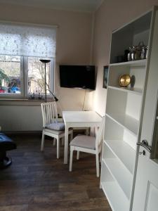 um quarto com uma mesa e cadeiras e uma televisão em Ferienwohnung Puttenusenhof em Klausdorf Brandenburg