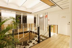una escalera en un edificio de oficinas con una barandilla de cristal en Green House Hotel en Barcelona