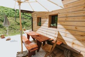 a wooden cabin with a table and chairs and an umbrella at Wine & Art Lodge Jeruzalem in Ljutomer