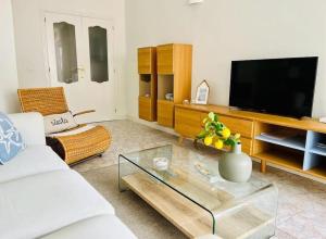 a living room with a white couch and a television at Luxe appartement op 50 meter van zee in Moraira in Moraira