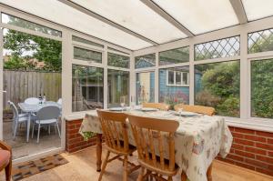 a conservatory with a table and chairs at Sea Mist in Southwold