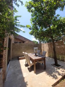 einen Holztisch und Stühle auf einer Terrasse mit einem Baum in der Unterkunft Nguni House in Mataffin