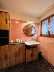 a bathroom with a sink and a mirror at Spitzen Blicke – Apartments in Silbertal