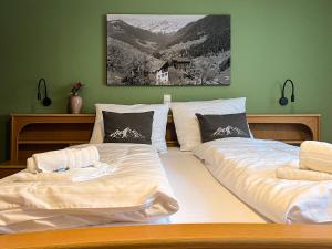 two beds in a bedroom with green walls at Spitzen Blicke – Apartments in Silbertal
