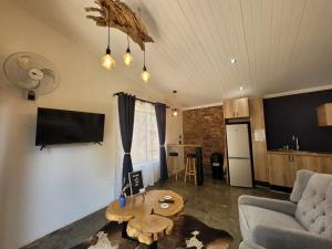 a living room with a couch and a table at Nguni House in Mataffin