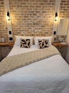 a bedroom with a large bed with a brick wall at Nguni House in Mataffin