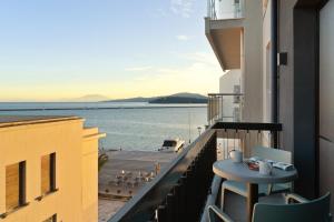 einen Balkon mit einem Tisch und Blick auf das Wasser in der Unterkunft Azur Hotel Volos in Volos