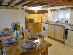 a kitchen with a wooden table with plates on it at Wren Cottage in Cwm