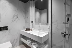 沃洛斯的住宿－Azur Hotel Volos，白色的浴室设有水槽和淋浴。