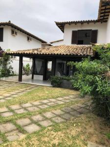 a house with a stone walkway in front of it at Praia de Geribá C 4 in Búzios