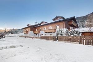 ein Haus mit einem Zaun im Schnee in der Unterkunft Tra-monti e Mare Bormio in Valdidentro