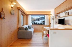 ein Wohnzimmer mit einem Sofa und einem Tisch in der Unterkunft Tra-monti e Mare Bormio in Valdidentro