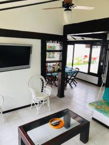 a living room with a tv and a table and chairs at Praia de Geribá C 4 in Búzios