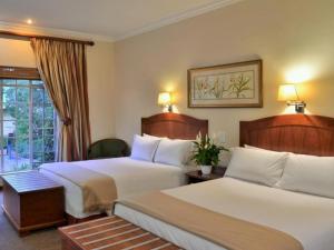 ein Hotelzimmer mit 2 Betten und einem Fenster in der Unterkunft Protea Hotel by Marriott Polokwane Ranch Resort in Polokwane
