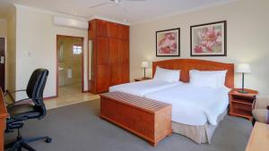 Schlafzimmer mit einem Bett, einem Schreibtisch und einem Stuhl in der Unterkunft Protea Hotel by Marriott Polokwane Ranch Resort in Polokwane