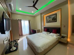 a bedroom with a large bed with a green light at GRACE INN A Premium Guest House, Near Airport & Ion Digital in Guwahati