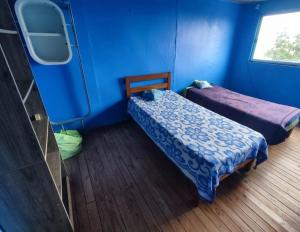 um quarto com duas camas e uma parede azul em Casa yeici em Viña del Mar