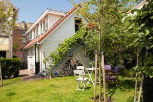 ein Haus mit einem Tisch und Stühlen im Hof in der Unterkunft B & B Villa Suisse in Scheveningen